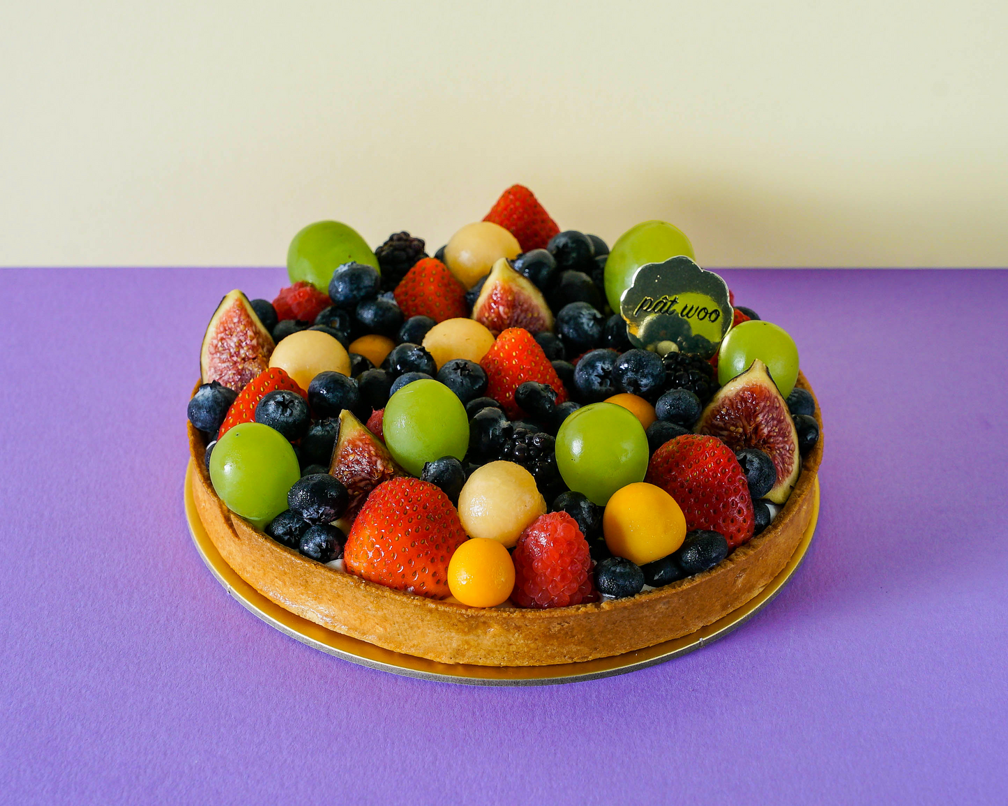 Fresh grapes, blueberries, strawberries and figs sitting atop a tart crust.